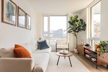 Vancouver apartment for rent - A living room with a white couch and a large window.