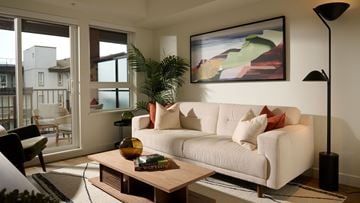 North Vancouver townhouse for rent - A living room with a white couch and a painting on the wall.