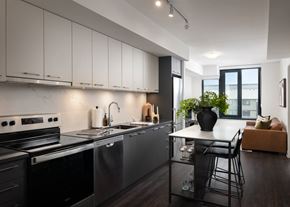 Mississauga apartment for rent - a kitchen with black appliances and a white counter top