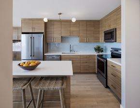 Oakland apartment for rent - a kitchen with wooden cabinets and a white island with a bowl of fruit