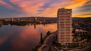 Oakland apartment for rent - a skyscraper overlooking a lake and a city at sunset