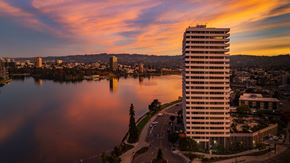 Oakland apartment for rent - a skyscraper overlooking a lake and a city at sunset