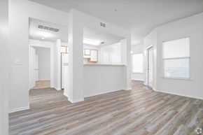 San Antonio apartment for rent - A room with white walls and wooden flooring with a doorway leading to another room at The Villages at Lost Creek Apartments, San Antonio, Texas