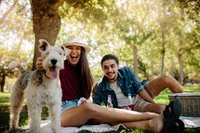 Johnson City apartment for rent - A man and woman are sitting on a blanket with a dog in a park.