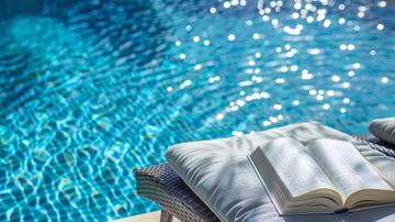 Moreno Valley apartment for rent - A book is open and lying on a pillow by a pool.