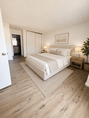 Oceanside apartment for rent - A bedroom with a large bed and a wooden floor.