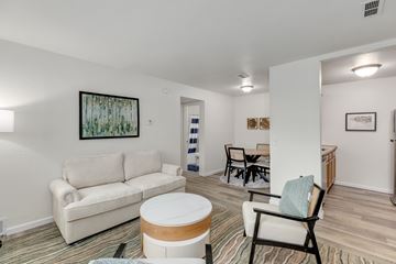 Clio apartment for rent - A living room with a white couch and a painting on the wall.