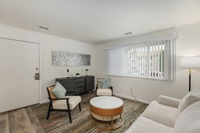 Clio apartment for rent - A living room with a white sofa, a wooden coffee table, and a grey couch.