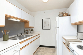 Cullman apartment for rent - A kitchen with white cabinets and a fridge.