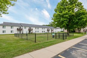 Clio apartment for rent - A row of white houses with green trees in front.