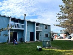 Rogers City apartment for rent - A blue two-story house with a balcony and a bicycle parked in front.