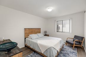 Clio apartment for rent - A bedroom with a bed, chair, and window.