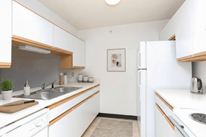 Manchester apartment for rent - A kitchen with white cabinets and a white fridge.