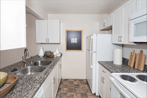 El Paso apartment for rent - A kitchen with white cabinets and a fridge.