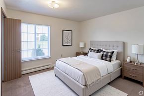 Howell apartment for rent - A bedroom with a large bed, nightstand, and window.
