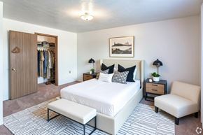 Augusta apartment for rent - A bedroom with a large bed, a chair, and a wardrobe.