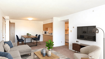 Radcliff apartment for rent - A living room with a grey couch, a coffee table, a television, and a dining table with chairs.