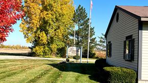 Kinde apartment for rent - the building where the motel is located is next to a flagpole with a sign