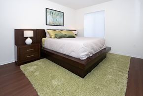 Fort Gratiot Twp apartment for rent - A bedroom with a bed, nightstand, and rug.