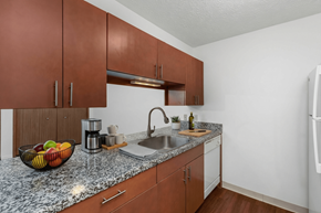 Augusta apartment for rent - A kitchen with brown cabinets and a marble countertop.