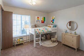 Augusta apartment for rent - A child's bedroom with a white bed, a wooden dresser, and a round mirror on the wall.
