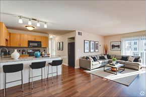 Toledo apartment for rent - A modern kitchen with a bar area and a living room with a couch.