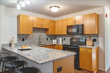 Toledo apartment for rent - A kitchen with wooden cabinets and granite countertops.