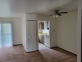 Ionia apartment for rent - an empty living room with a ceiling fan and a kitchen