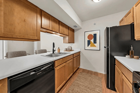 Manchester apartment for rent - A kitchen with wooden cabinets and black appliances.