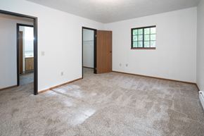 Harbor Beach apartment for rent - an empty living room with carpet and a door to a bathroom