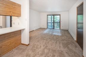 Caseville apartment for rent - an empty living room with a door to a balcony