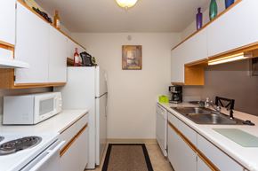 Fenton apartment for rent - A kitchen with white cabinets and a white microwave.