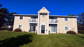 Lapeer apartment for rent - a large yellow house with a white roof and a balcony