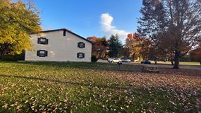 Coopersville apartment for rent - a house with a picnic table in a field with leaves on the ground