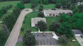 Dewitt apartment for rent - an aerial view of a house with a parking lot and a yard with trees