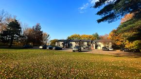 Coopersville apartment for rent - a house in the middle of a grassy field with cars parked in front of it