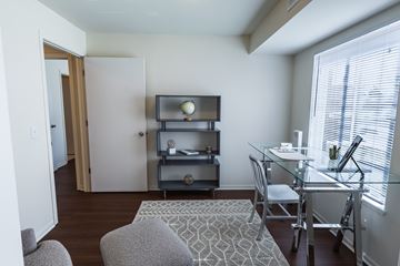 Toledo apartment for rent - A living room with a grey couch, a glass table, and a television on a stand.
