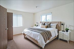 Evansville apartment for rent - A bedroom with a bed, nightstand, and window.