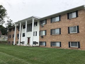 Portland apartment for rent - a large brick building with white siding and a large grassy area in front of it