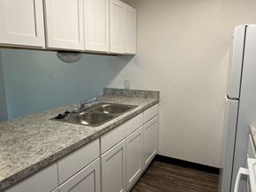 Waskom apartment for rent - a kitchen with white cabinets and a sink and a refrigerator