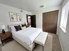 Waskom apartment for rent - A bedroom with a large bed and a nightstand with a lamp.