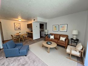 Malakoff apartment for rent - A living room with a blue couch, a wooden coffee table, and a lamp.