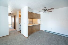 Lexington apartment for rent - an empty living room with a ceiling fan and a kitchen