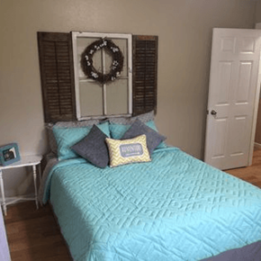 Portland apartment for rent - a bedroom with a bed and a wreath on the wall