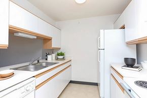 Hopkinsville apartment for rent - A small, clean kitchen with white cabinets and appliances.