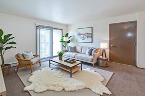 Hopkinsville apartment for rent - A living room with a white rug and a wooden coffee table.