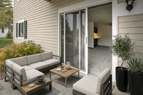 Kendallville apartment for rent - A patio with a grey couch, a wooden coffee table, and a potted plant.