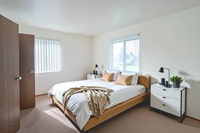 Dothan apartment for rent - A bedroom with a bed, nightstand, and window.