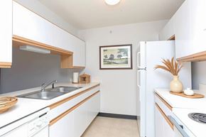 Dothan apartment for rent - A kitchen with white cabinets and a fridge.