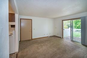 Gobles apartment for rent - an empty living room with a sliding glass door to a patio